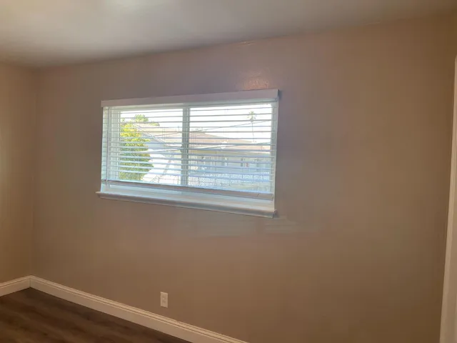a view of a small space with wooden floor and a window