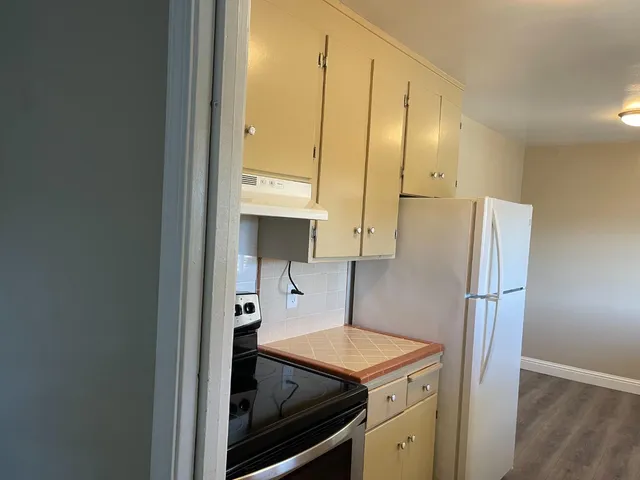 a kitchen with stainless steel appliances a refrigerator and wooden floor