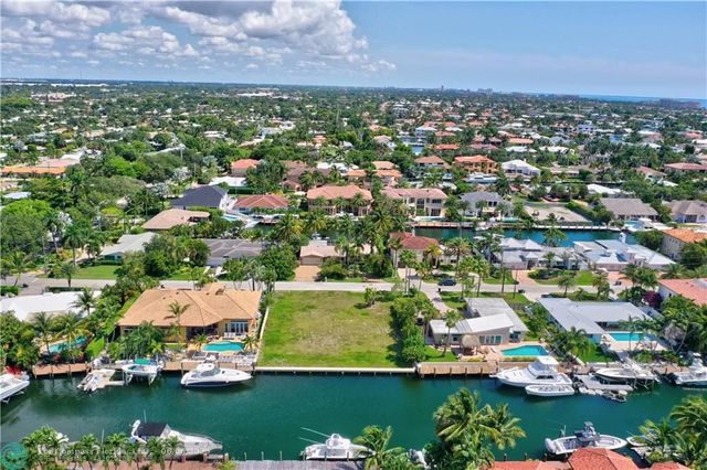 an aerial view of residential houses with outdoor space and lake view