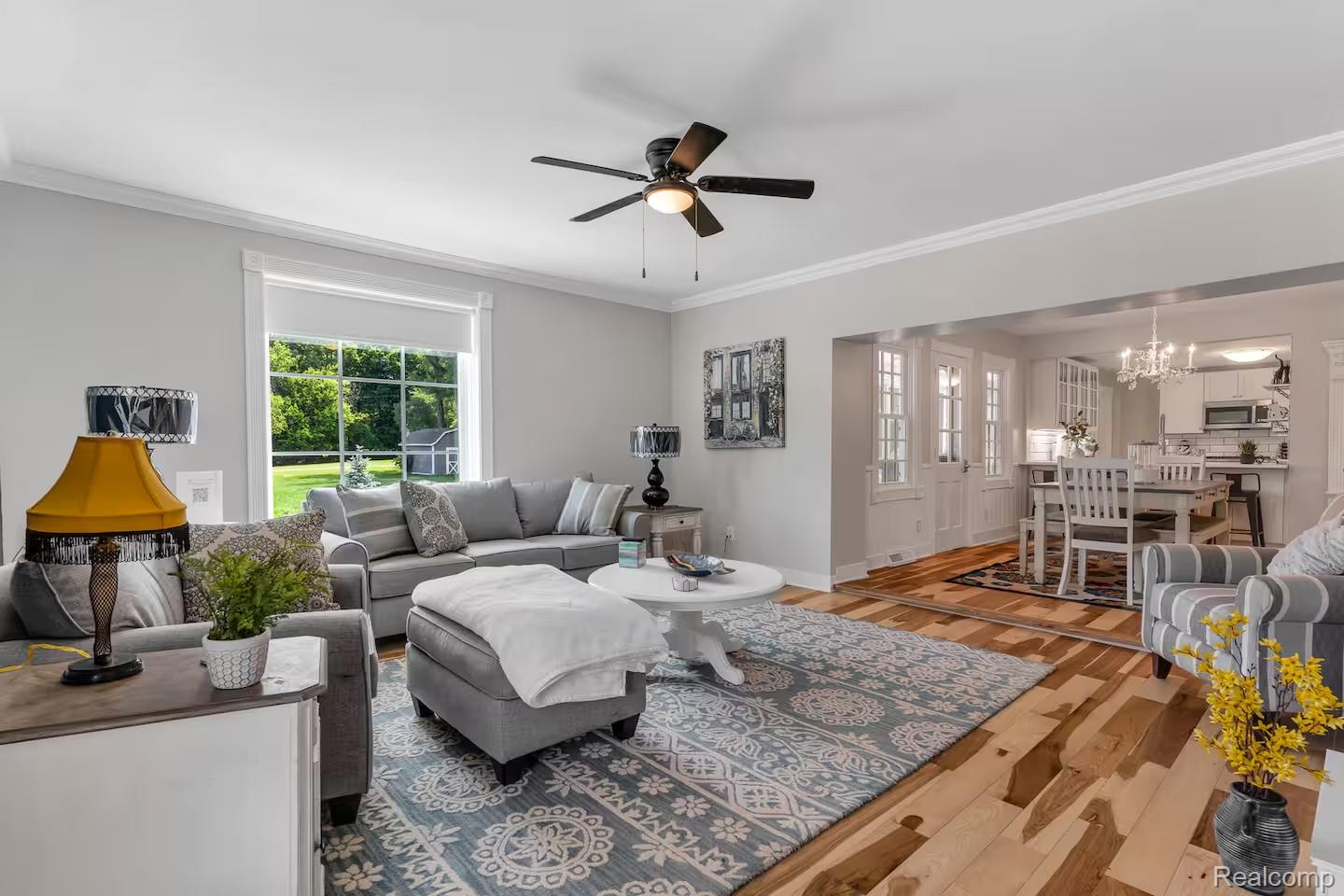 4567 North Seymour Road Flushing, MI 48433 - Photo 18 of 43 Spacious living area featuring wide-plank wood-finish flooring, a ceiling fan, and a large window providing ample natural light