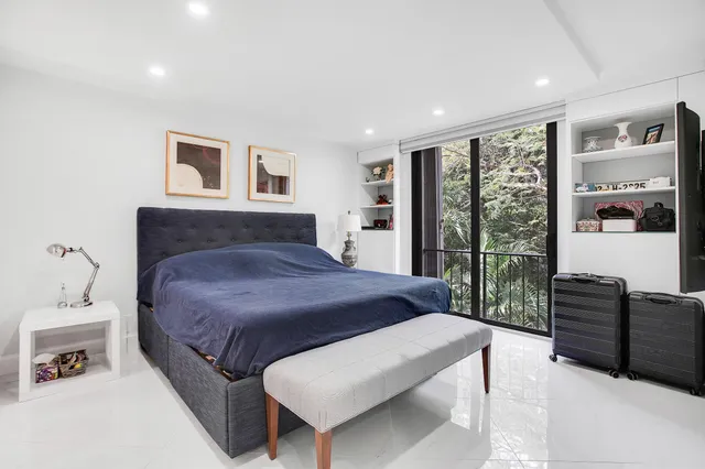 a bedroom with a large bed and wooden floor
