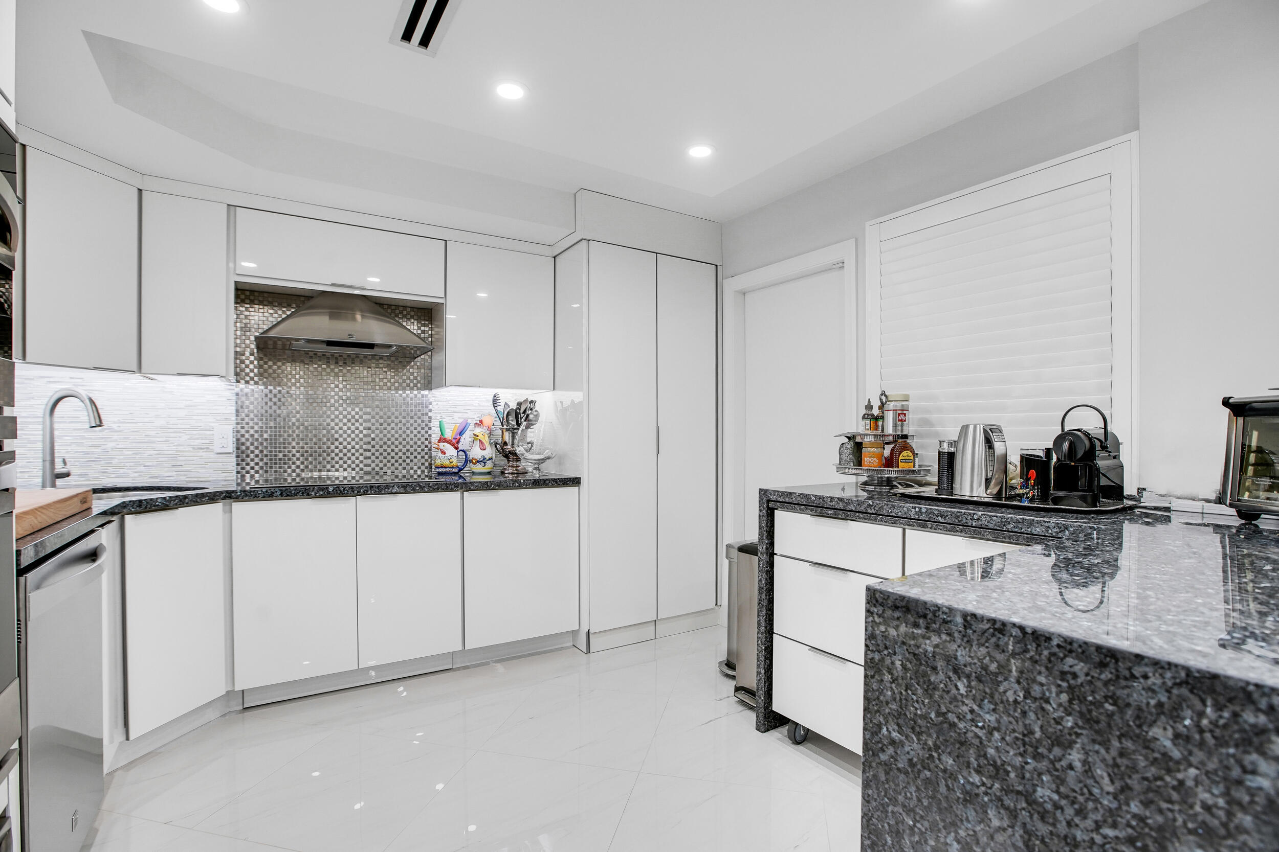 501 Southwest 11th Place, Unit 317 Boca Raton, FL 33432 - Photo 18 of 28 a kitchen with stainless steel appliances granite countertop a sink stove and cabinets