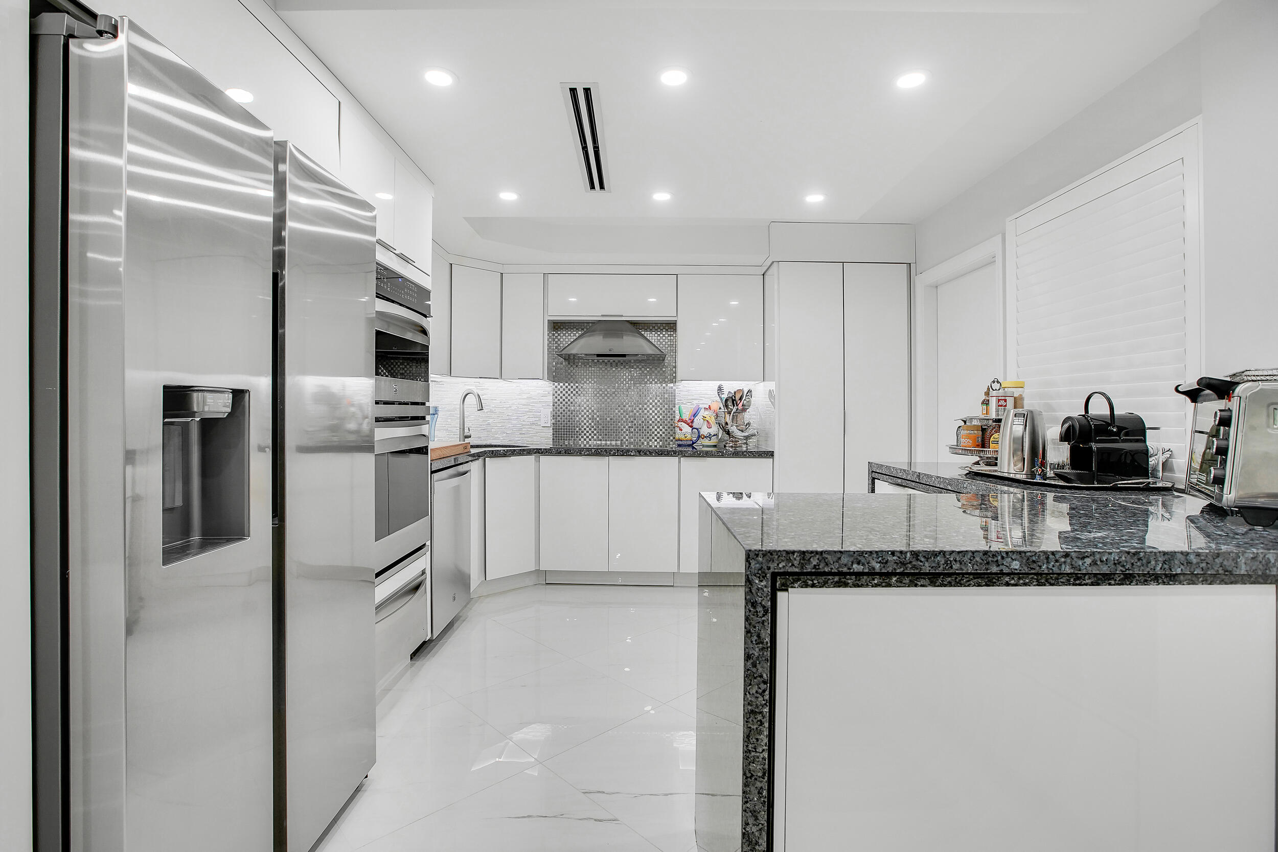 501 Southwest 11th Place, Unit 317 Boca Raton, FL 33432 - Photo 19 of 28 a kitchen with granite countertop a refrigerator and a sink