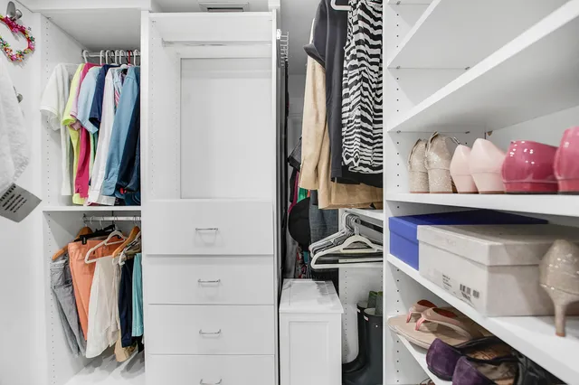 a view of walk in closet with clothes and shoes