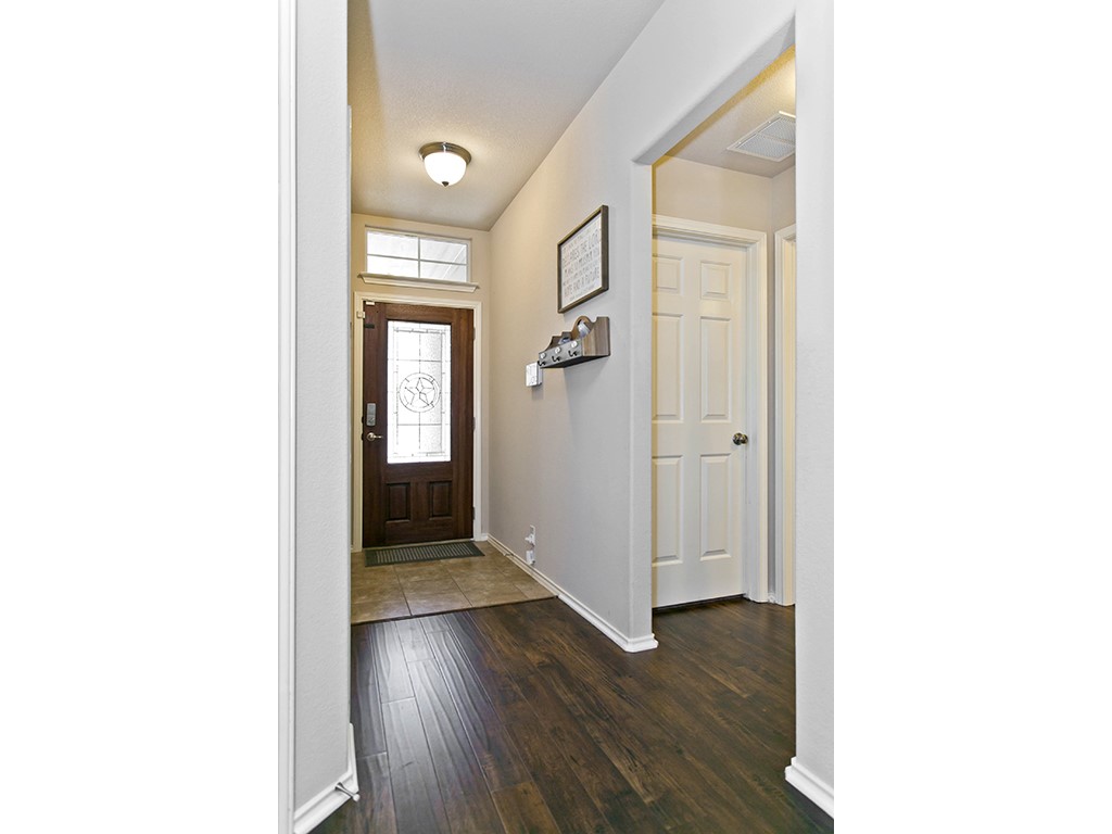 1808 Sand Creek Road Cedar Park, TX 78613 - Photo 13 of 25 Entryway featuring dark wood-finish flooring, a ceramic tile landing, and a paneled entry door with decorative glass