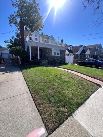 a front view of a house with a garden and trees