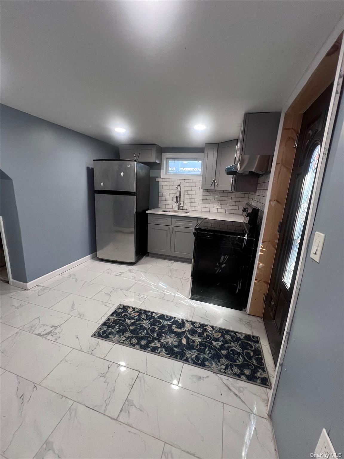 44 Frank Street Valley Stream, NY 11580 - Photo 18 of 23 a kitchen with stainless steel appliances a refrigerator a sink a stove a microwave and cabinets