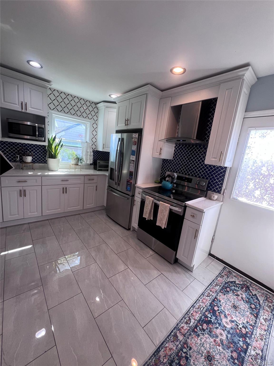 44 Frank Street Valley Stream, NY 11580 - Photo 9 of 23 a kitchen with stainless steel appliances granite countertop a refrigerator stove top oven and sink