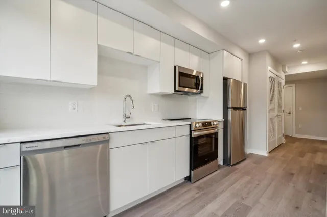 a kitchen with stainless steel appliances a refrigerator sink and microwave