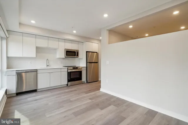 a large kitchen with a refrigerator sink and stove