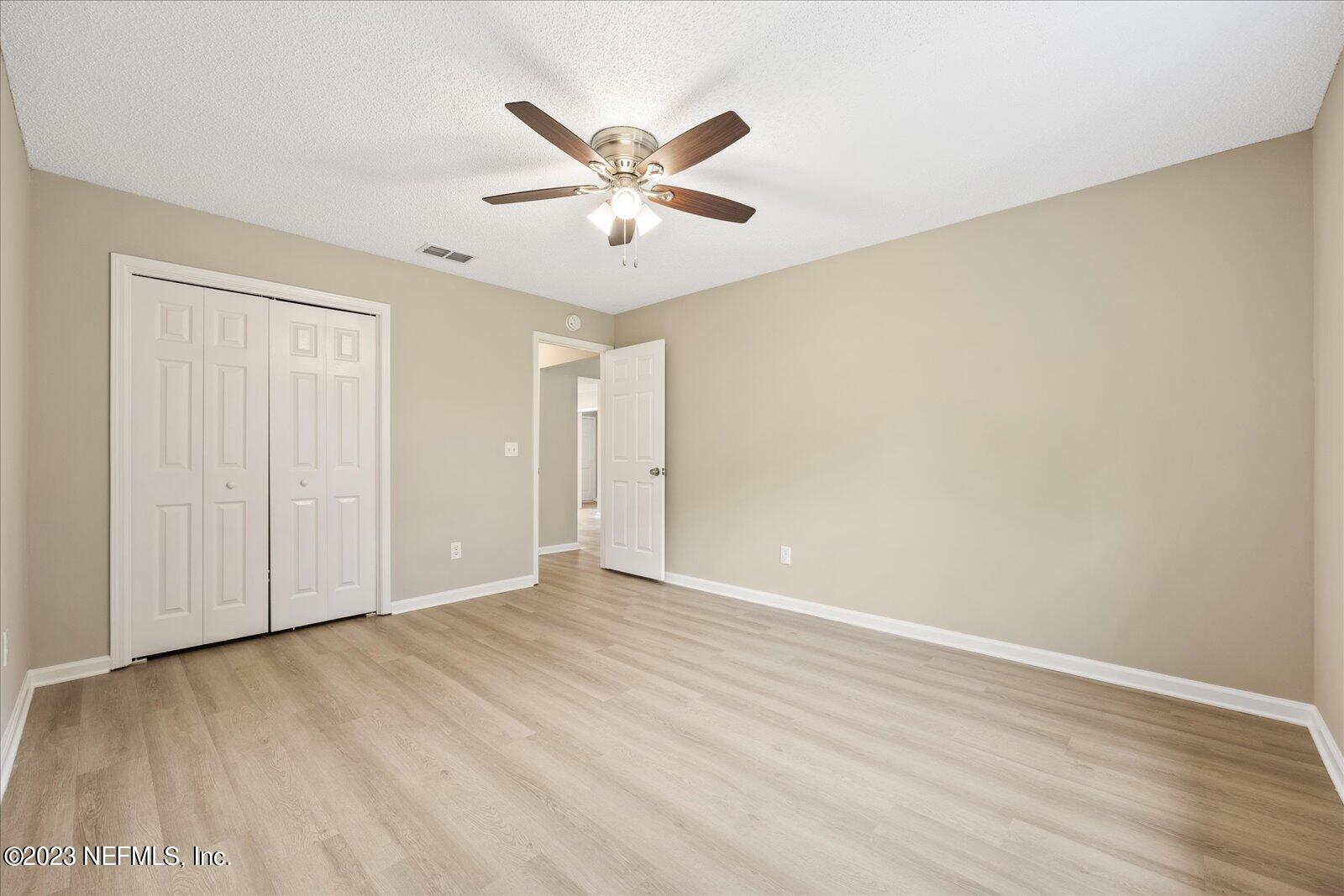 1566 Rusty Rail Road Jacksonville, FL 32225 - Photo 34 of 45 a view of an empty room with wooden floor and a ceiling fan