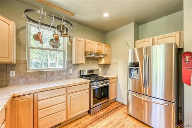a kitchen with stainless steel appliances a refrigerator sink and microwave