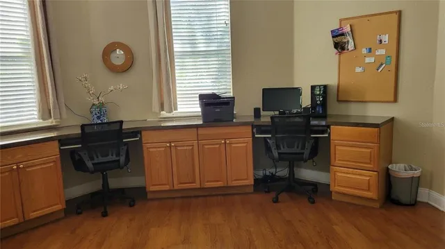 a view of workspace with wooden floor windows