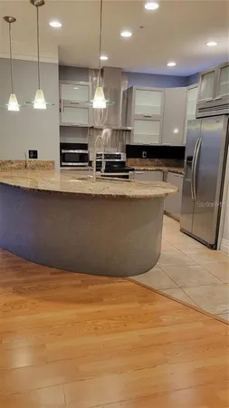 a large kitchen with stainless steel appliances a large counter top