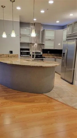 a large kitchen with stainless steel appliances a large counter top