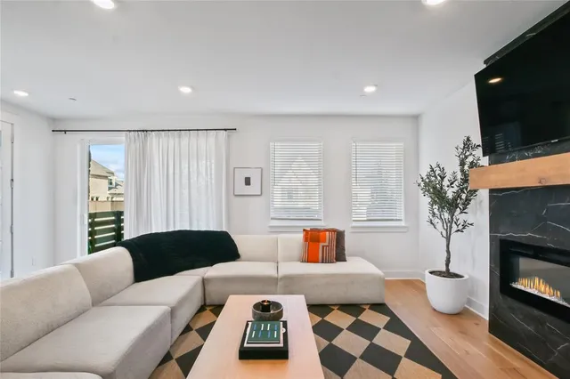 a living room with furniture a flat screen tv and a fireplace