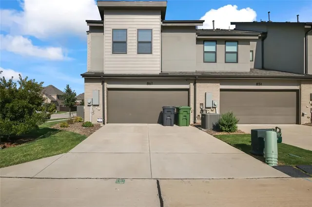 a front view of a house with a yard and potted plants