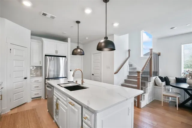 a kitchen with white cabinets and stainless steel appliances