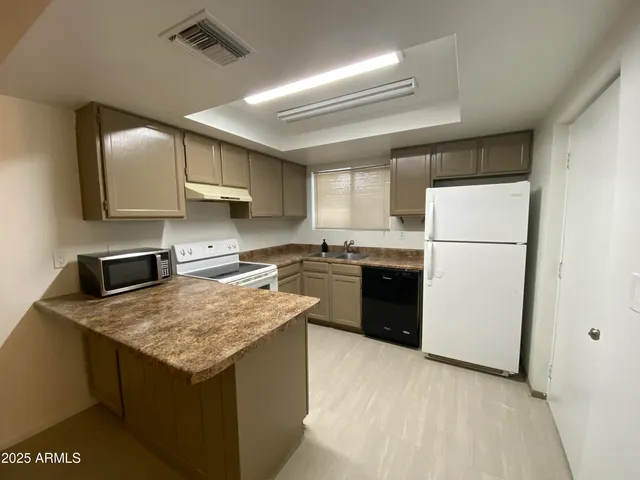 a kitchen with a sink a stove a refrigerator and a refrigerator