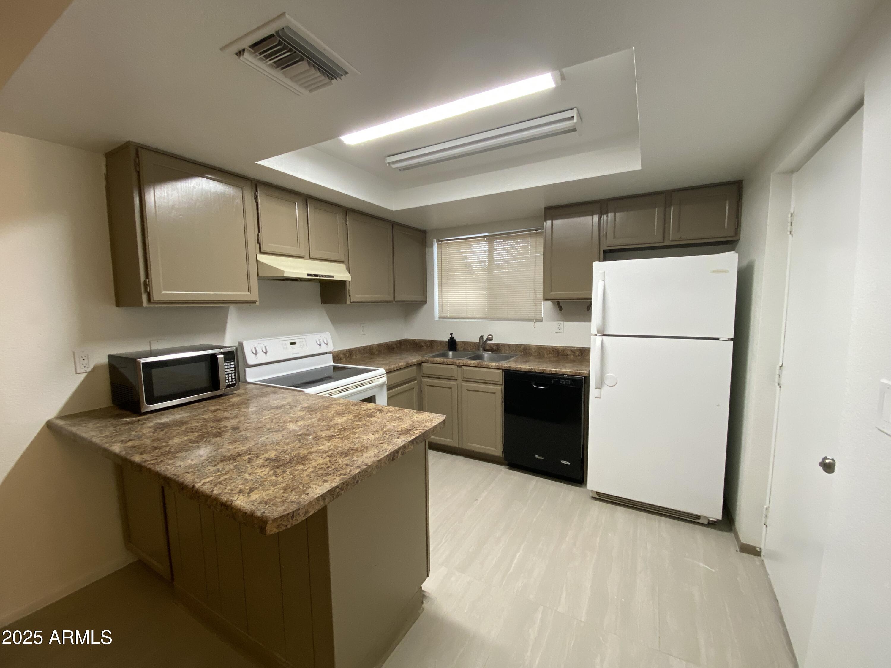416 West Pebble Beach Drive Tempe, AZ 85282 - Photo 3 of 7 a kitchen with a sink a stove a refrigerator and a refrigerator