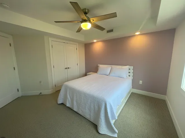 a bedroom with a bed and a ceiling fan