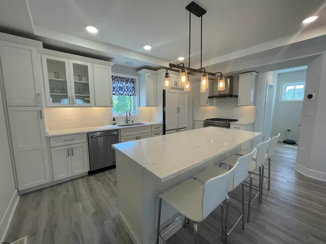 a kitchen with a dining table chairs stainless steel appliances and cabinets