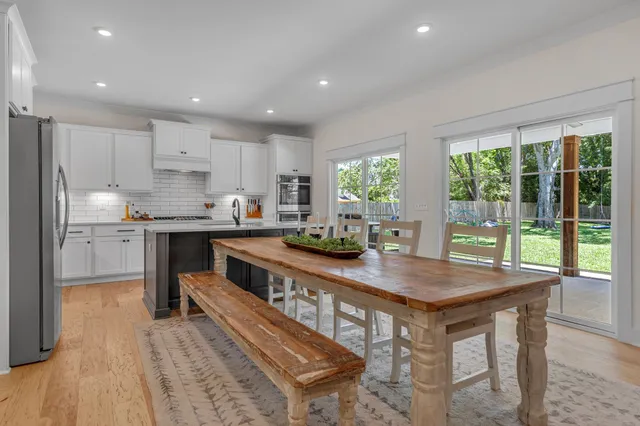 a kitchen with kitchen island a refrigerator and a stove top oven