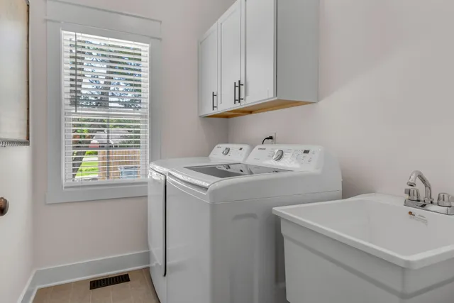 a bathroom with double vanity sink a two mirror a window and a bathtub