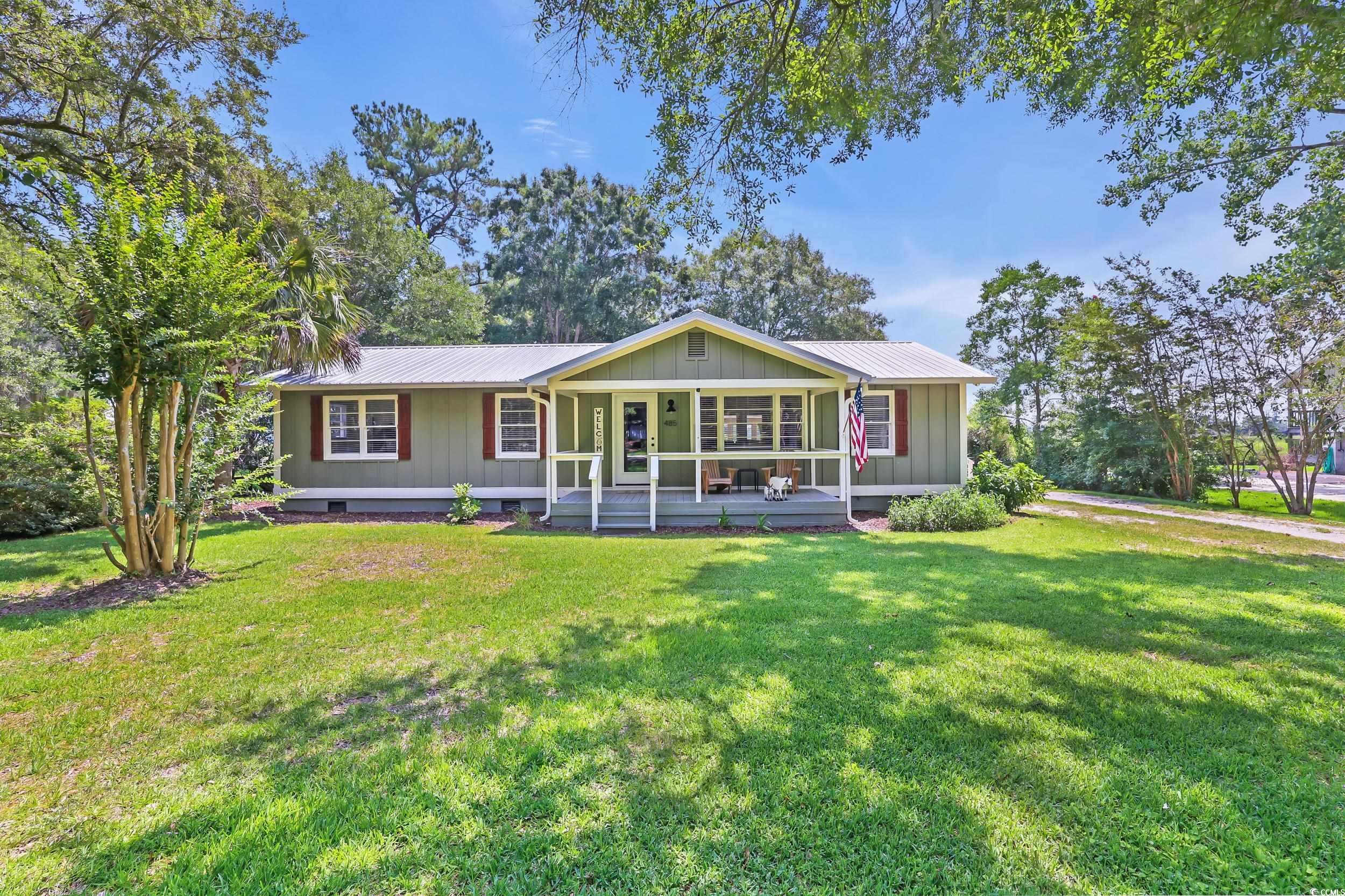 485 County Rd S-22-592 Georgetown, SC 29440 - Photo 1 of 40 View of front facade with covered porch, a metal roof, board and batten siding, and a front yard