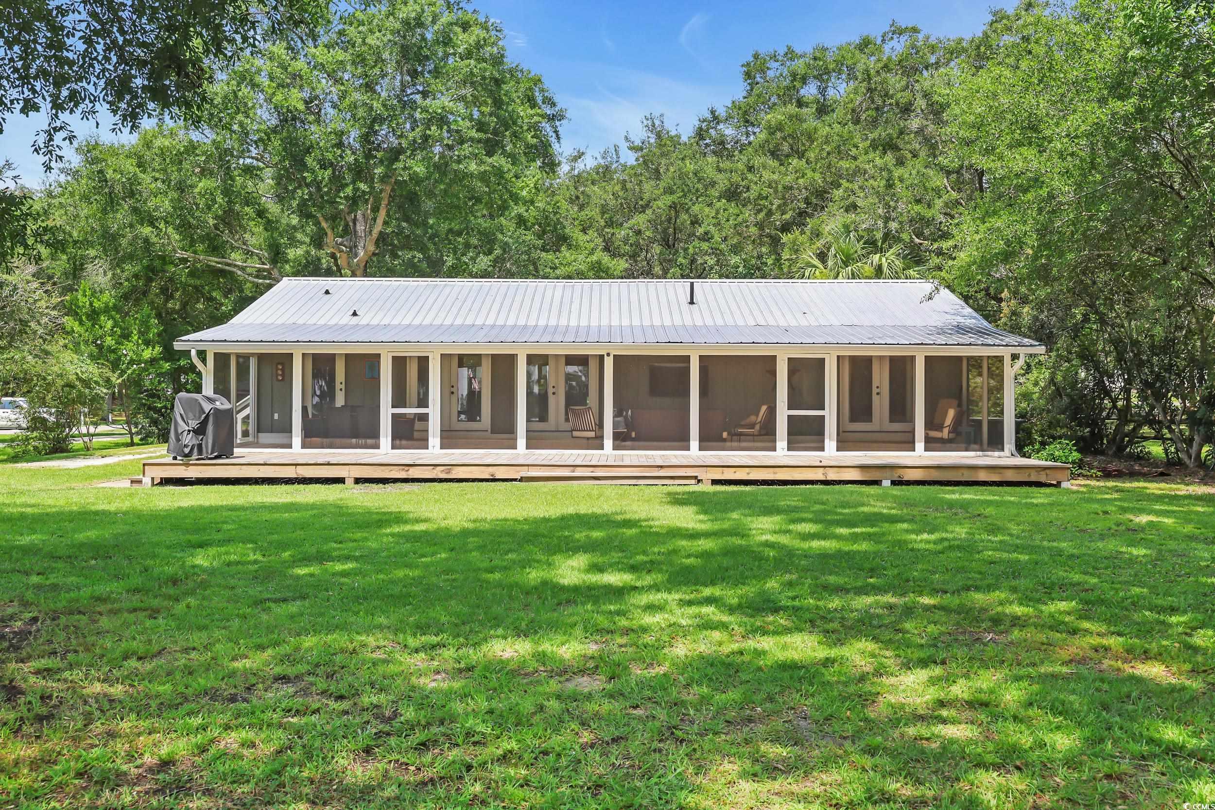 485 County Rd S-22-592 Georgetown, SC 29440 - Photo 25 of 40 Back of house featuring a sunroom, a lawn, and a metal roof