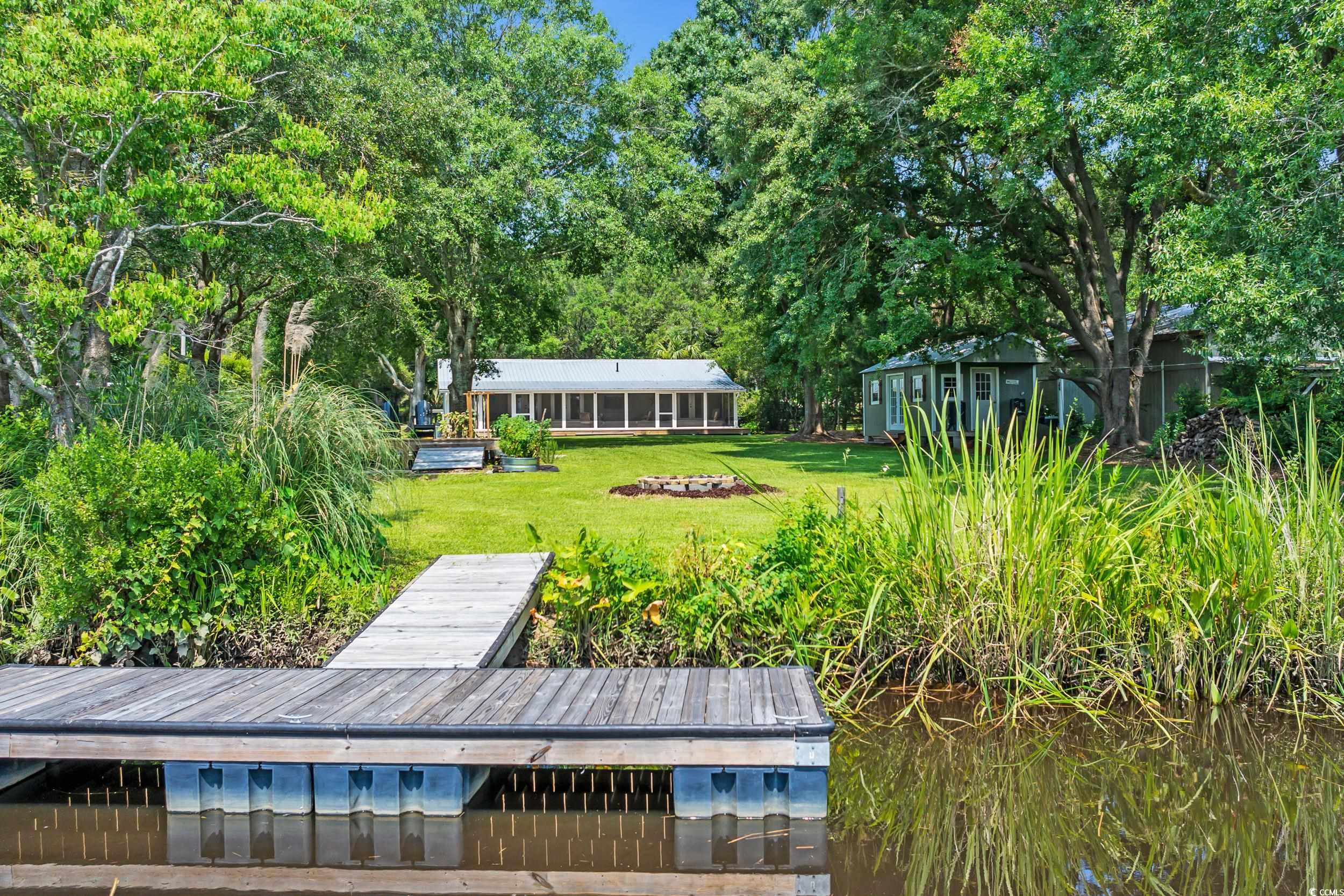 485 County Rd S-22-592 Georgetown, SC 29440 - Photo 33 of 40 View of green lawn with a floating dock and an outbuilding