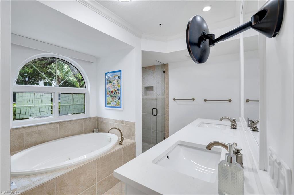 376 3rd Street South, Unit 102 Naples, FL 34102 - Photo 12 of 17 a bathroom with a tub a sink and a large window