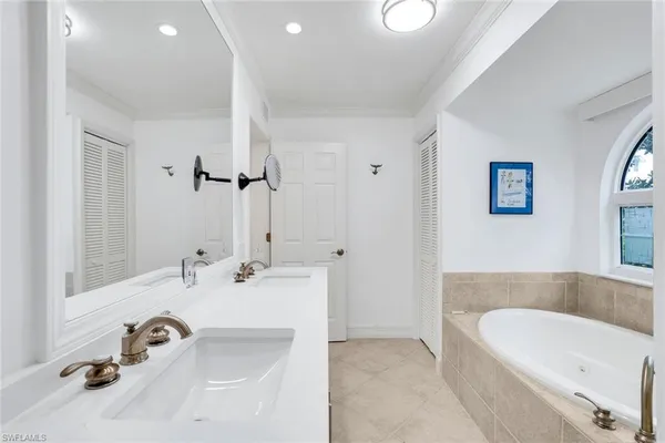 a bathroom with a tub sink and mirror