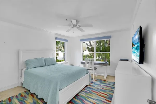 a bedroom with a bed and a large window