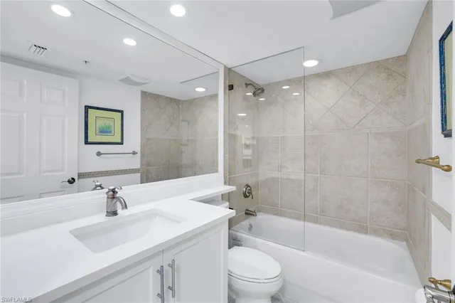 a bathroom with a bathtub shower sink vanity and toilet