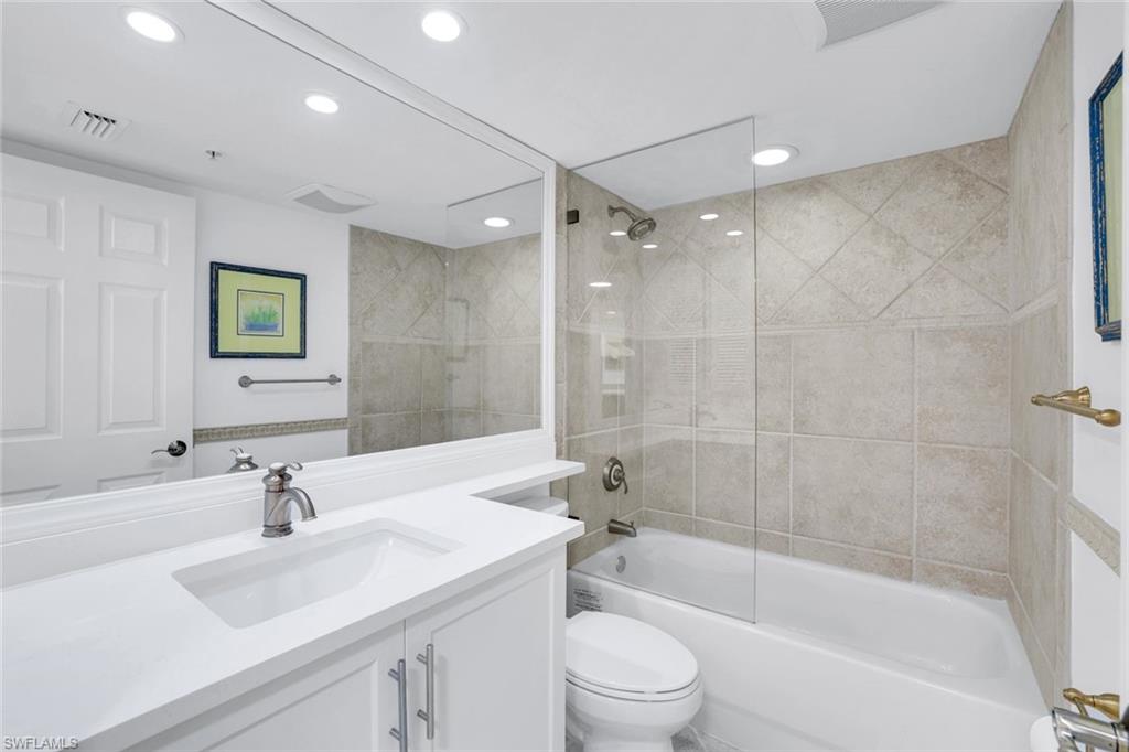 376 3rd Street South, Unit 102 Naples, FL 34102 - Photo 15 of 17 a bathroom with a bathtub shower sink vanity and toilet
