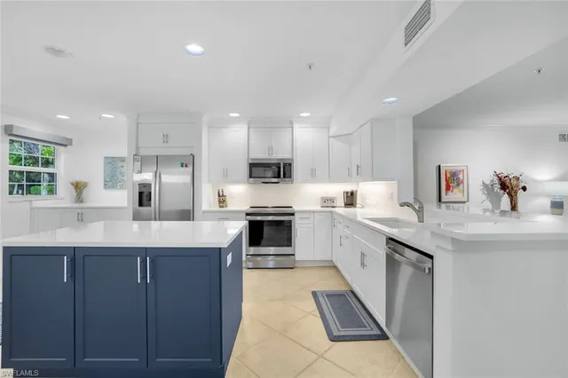 a large kitchen with stainless steel appliances lots of counter space and a sink