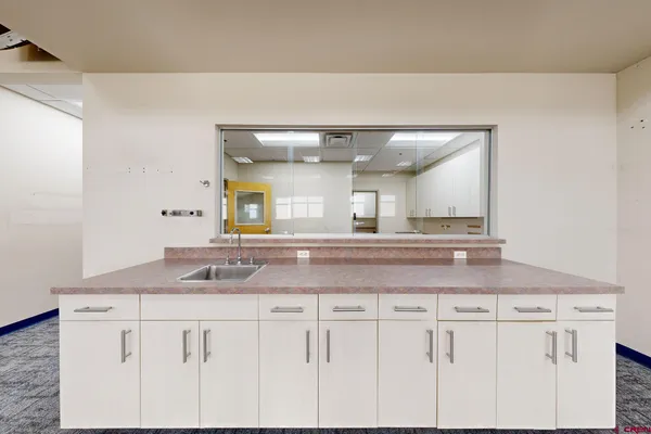 a kitchen with a sink a stove and cabinets