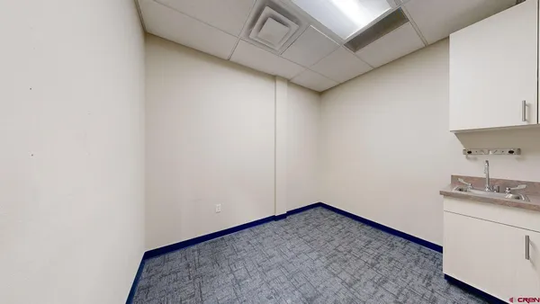 a view of a kitchen with white cabinets and wooden floor