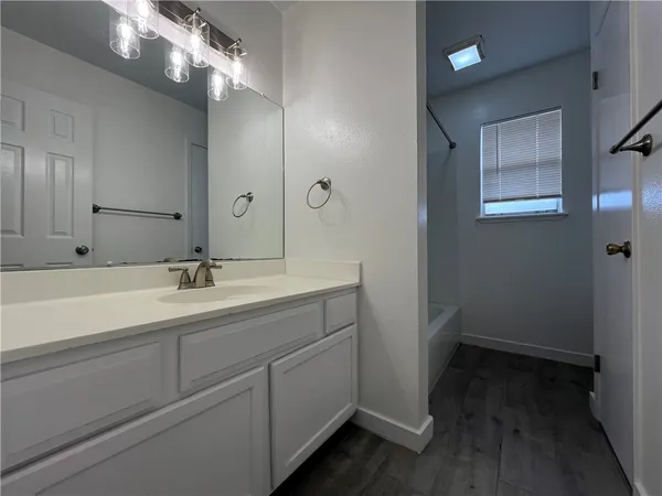 a bathroom with a sink a large mirror and vanity