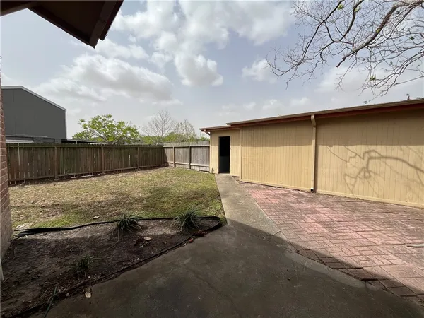 a view of backyard with wooden fence