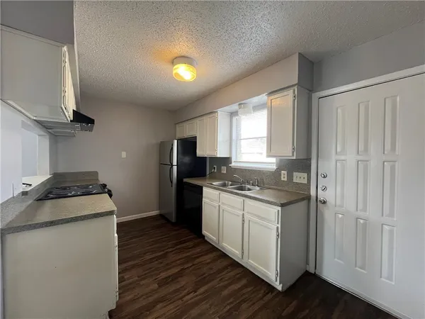 a kitchen with granite countertop a sink stove and refrigerator
