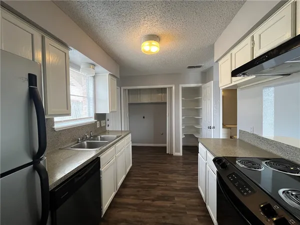 a kitchen with stainless steel appliances granite countertop a stove a sink and a refrigerator