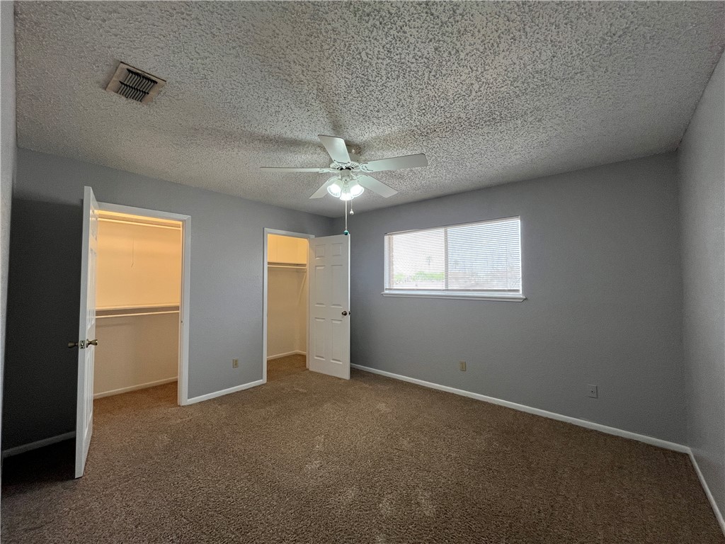 6533 Long Meadow Drive, Unit A Corpus Christi, TX 78413 - Photo 10 of 21 an empty room with windows and chandelier fan