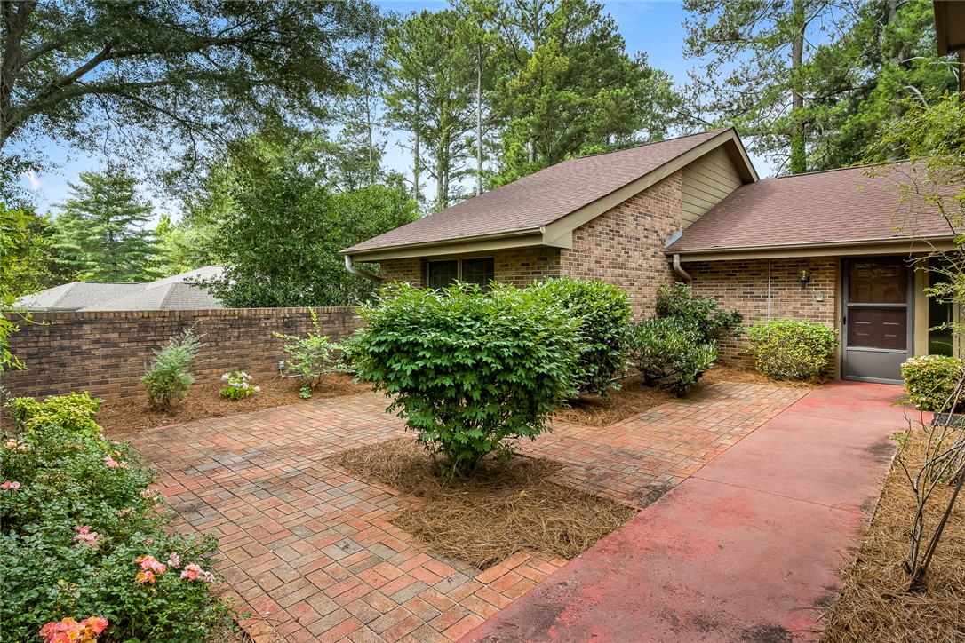 34 Hickory Way Clemson, SC 29631 - Photo 4 of 39 A quaint brick home nestled among mature trees with a charming brick pathway leading to the entrance.