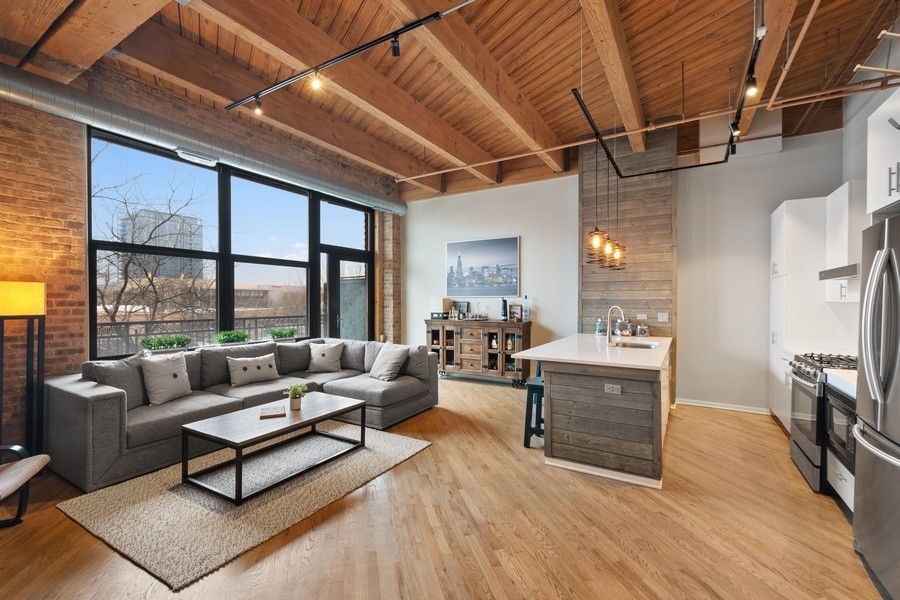 1040 West Adams Street, Unit 239 Chicago, IL 60607 - Photo 2 of 12 a living room with furniture a fireplace and a table