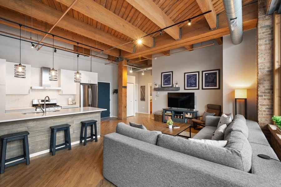 1040 West Adams Street, Unit 239 Chicago, IL 60607 - Photo 3 of 12 a living room with furniture a fireplace and a flat screen tv