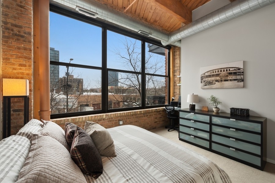 1040 West Adams Street, Unit 239 Chicago, IL 60607 - Photo 6 of 12 a bed sitting in a bedroom next to a large window