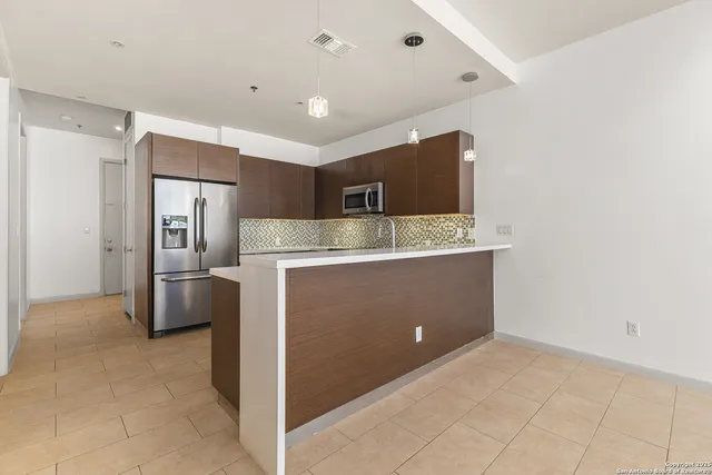 a view of kitchen with cabinets and refrigerator