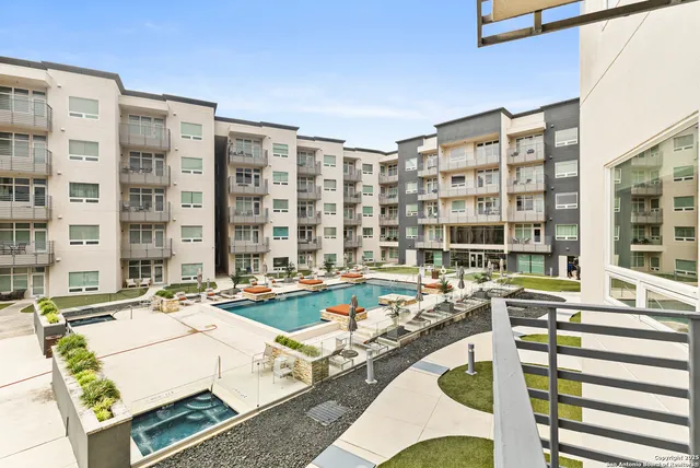 a large white building with glass top table and chairs
